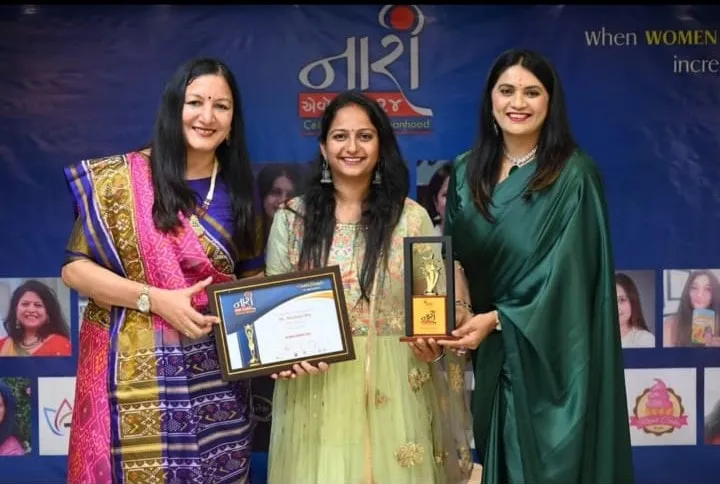Dr. Meghna Oza holding an award and a certificate at a women achievers event